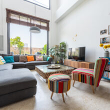 Real estate photographer Amsterdam — styled designer living room with sectional sofa, bookshelf, and curated décor