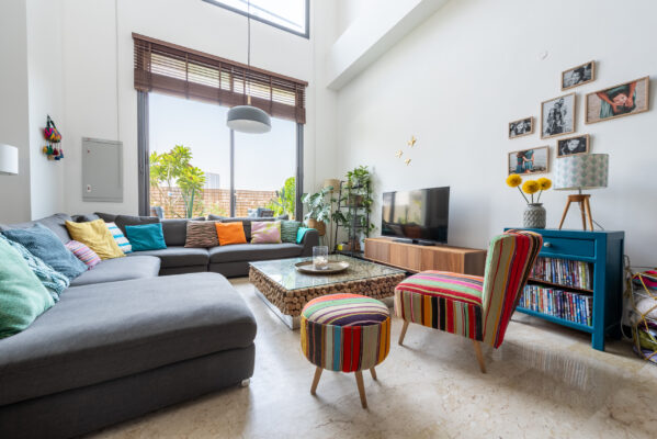 Real estate photographer Amsterdam — styled designer living room with sectional sofa, bookshelf, and curated décor