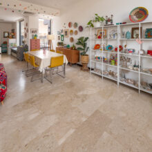 Real estate photography of a dining area with table, chairs, and white display shelving styled with décor