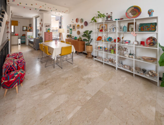 Real estate photography of a dining area with table, chairs, and white display shelving styled with décor