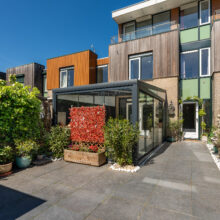 Real estate photography of a modern townhouse exterior with planted terrace and timber cladding