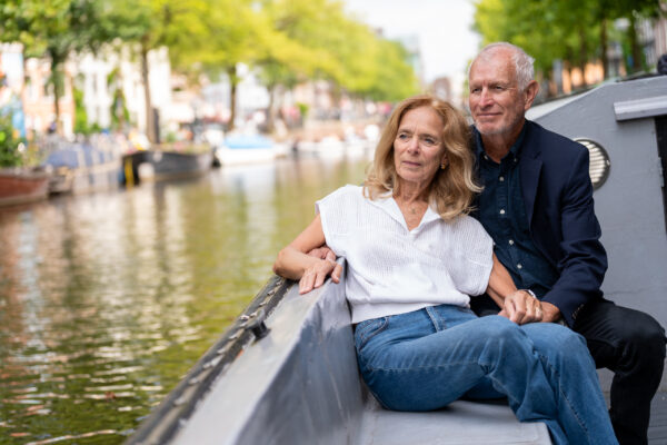 Travel portrait of couple enjoying a canal boatride in Amsterdam — visiting travellers shoot