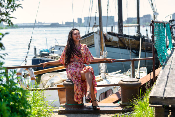 Portrait photographer Amsterdam — woman in floral dress on a moored boat at NDSM Wharf, Amsterdam Noord
