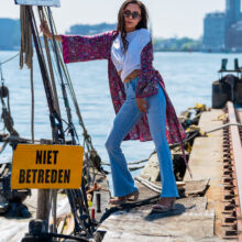 Fashion portrait of woman in flowing outfit on industrial pier at NDSM, Amsterdam Noord