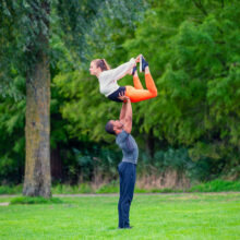 Lifestyle photographer Amsterdam — acrobatic duo demonstrating strength and balance on the lawns of Westerpark