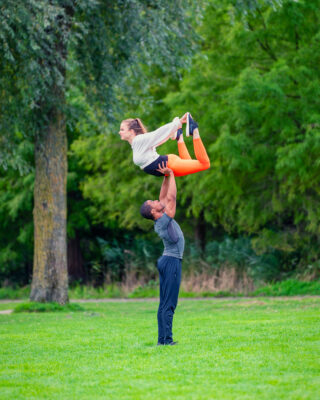 Lifestyle photographer Amsterdam — acrobatic duo holding a lift on the lawns of Westerpark