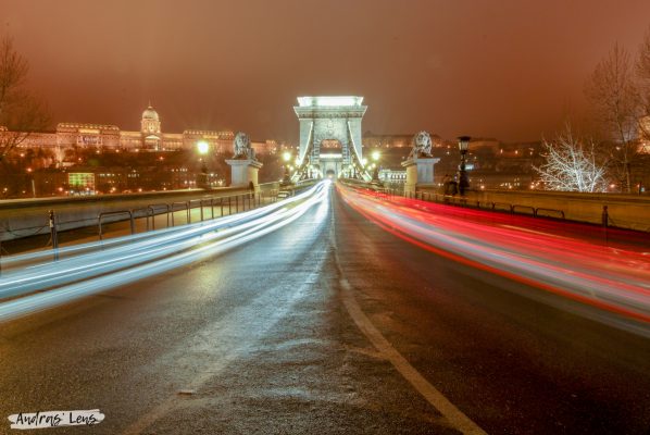 A photography capturing the ambience of a foggy winter night at the Chain Bridge in Budapest.