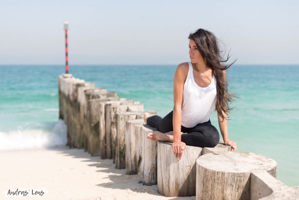 Photograph of a young lady doing yoga on a pier in Dubai.